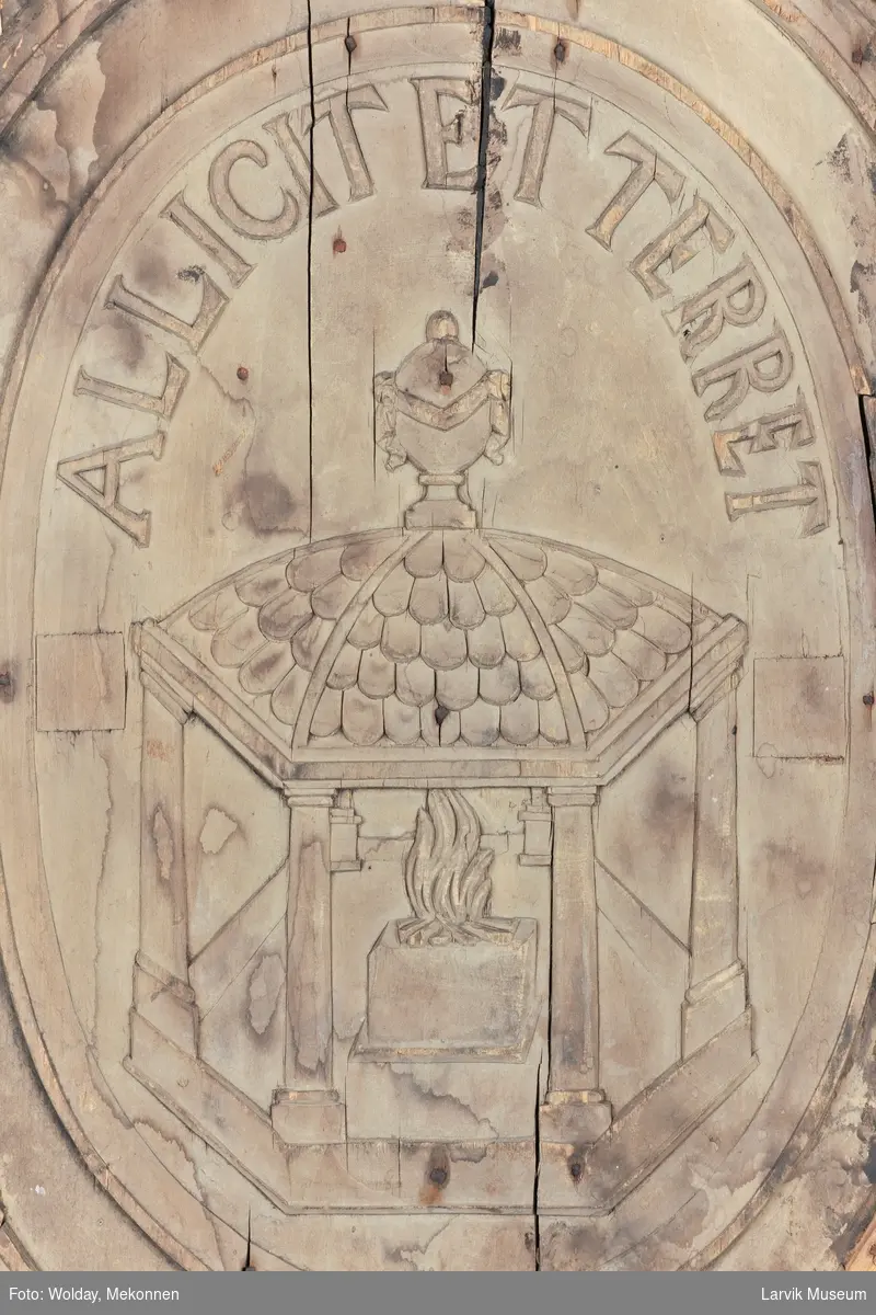 De fire kvinnefigurer skal forestille "De fire elementer", nemlig luft, ild, vann og jord.
I midtfeltet; et tempel med brennende alter. "Allicet et terret" betyr "Den lokker og skremmer"