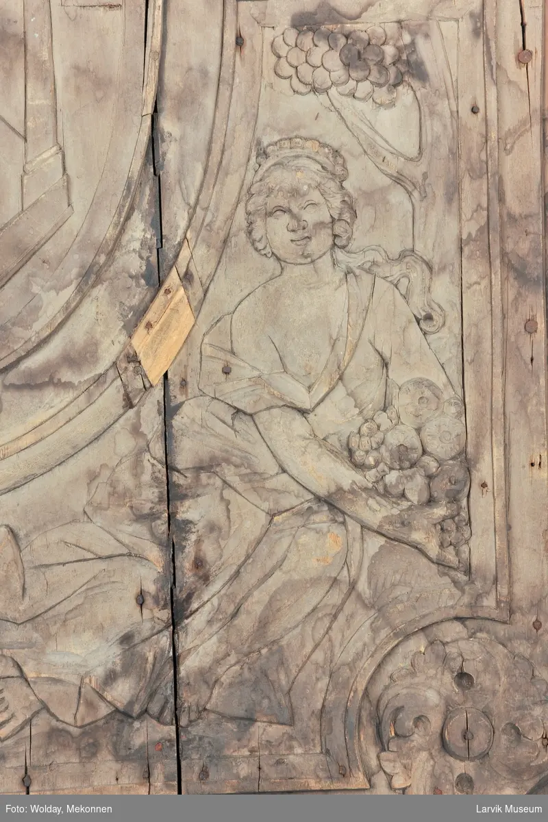 De fire kvinnefigurer skal forestille "De fire elementer", nemlig luft, ild, vann og jord.
I midtfeltet; et tempel med brennende alter. "Allicet et terret" betyr "Den lokker og skremmer"