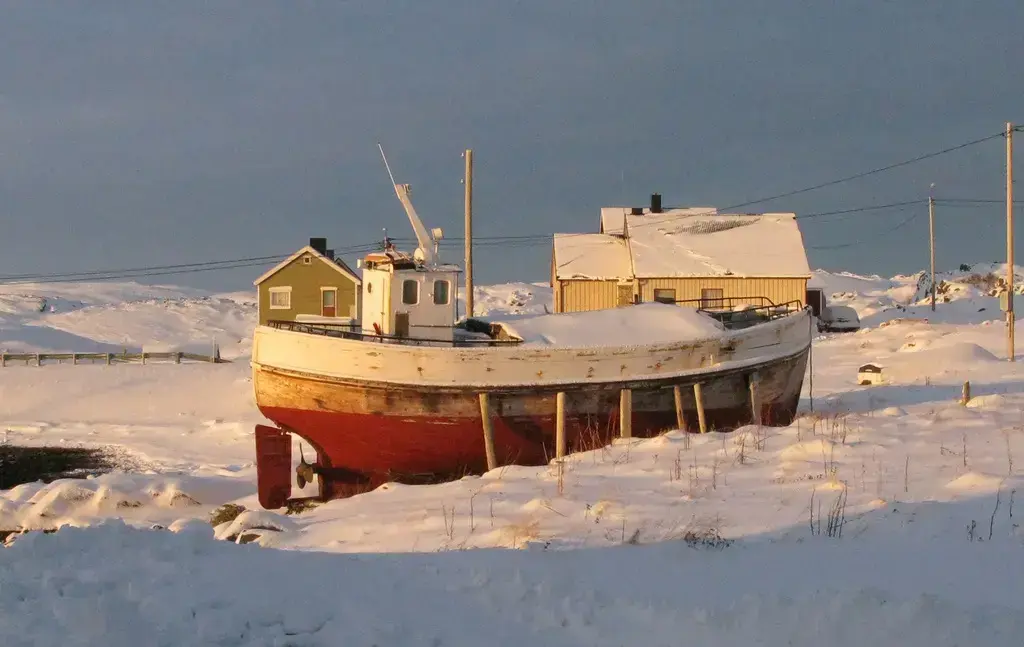 Båt i sollys og snø.