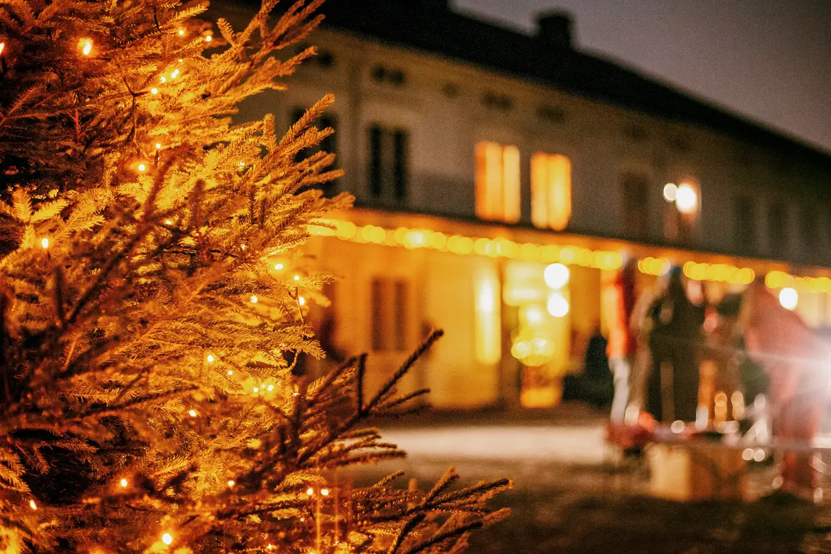 Juletre med lys står foran hovedbygningen på Linderud gård.