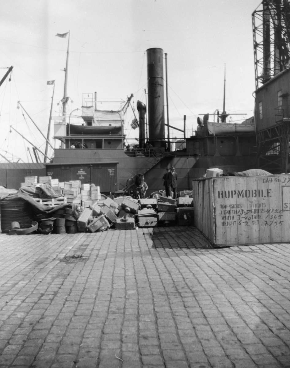 Fra et kaianlegg. Stor kasse merket "Hupmobile" (amerikansk bilmerke), godsvogn fra Norges Statsbaner ved båten.