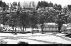 Vy från väster över södra delen av Gränna torg. Det ligger snö på marken. Enstaka bilar parkerade på torget.