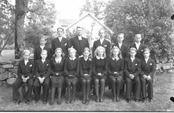 Mörkklädd konfirmandgrupp med kykoherde Erik Lesser.