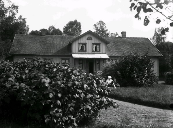 Drängsereds prästgård. Bild 1: Mia Lindeskog sitter vid ett buskage i trädgården med ett österikiskt krigsbarn ca 1920. Bild 2: Prästgården sedd från andra hållet med en plöjd åker i förgrunden.