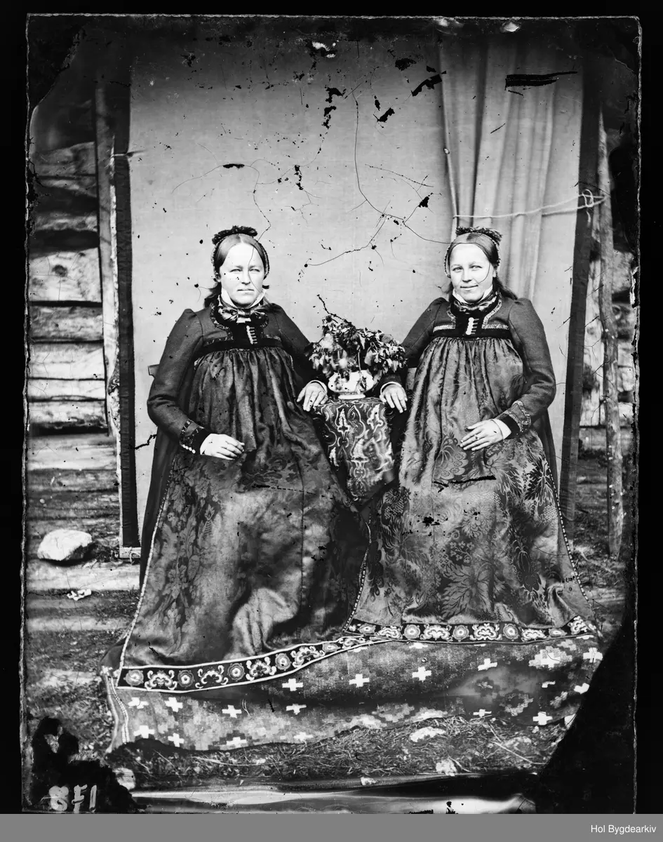 Helga Knutsdtr. Ellingsgard-Pettersen (1849-1920) og Kristi Knutsdtr. Ellingsgard-Langegard (1851-1919).
PortrettH2, kvinne, hallingklede, bunad, fotoatelier