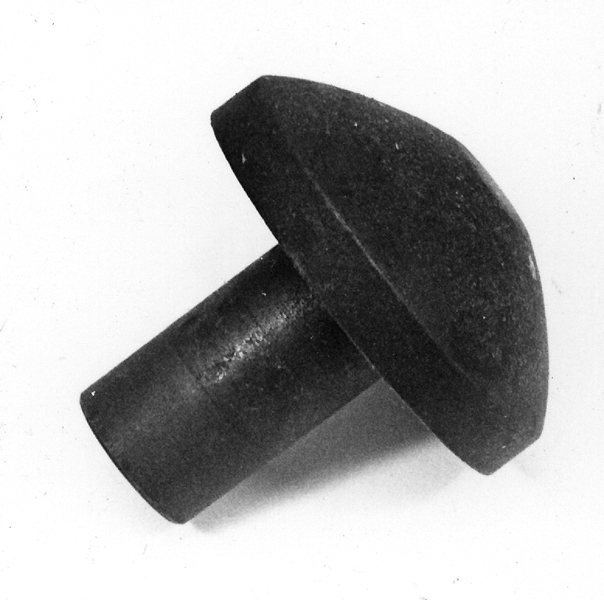 Stans och stansform (a-b). a) Stansplatta av stål. Cirkelrund med konvex profil (teckning). Längd 6,5 cm. Diameter 6,5 cm. b) Stansform av stål. Rektangulär med cylinderformad uppbyggnad i centrum. Längd 22 cm. Bredd 7,5 cm. Höjd 7 cm. 