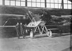 Två volontära flygsoldater står framför flygplan S 6, Fokker C. V i en hangar. Omkring 1937.