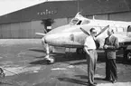 Flygplan Tp 46 Dove tillhörande F 8 Barkarby står på flygplatsen i Hamburg, 1952. Två män i förgrunden.