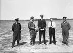 Gruppfoto av fem män på ett flygfält, omkring 1930-1940-tal. Från höger: förman P. Nilsson, löjtnant Hägglov, löjtnant Lindqvist, löjtnant Gisslander, Ivar Carlsson.