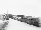 Centrala flygverkstäderna i Malmslätt, 1920-tal. Landsvägen från Malmslätt. Monteringshallen på höger sida. Flygplan FVM S 18 och Albatros parkerade.