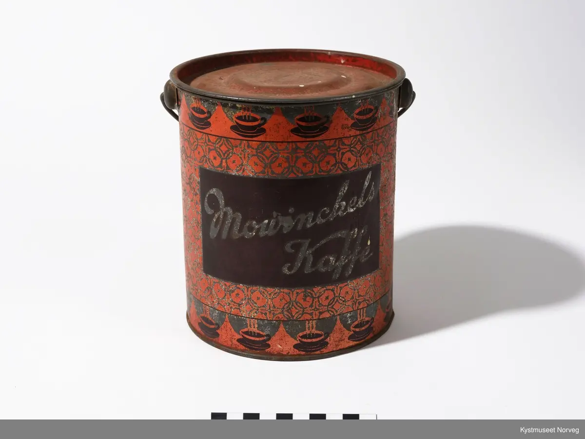 Malt rød, med påtrykt krans av kaffekopper øverst og nederst på boksen og midt på boksen ett firkantet felt med påskriften Movinchels Kaffe