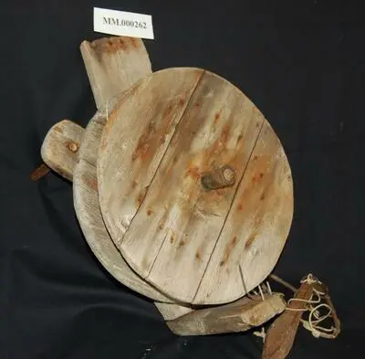 Et juksahjul i tre, liggende på en sort duk.