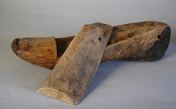 Ett par läster av trä. Varje läst består av två delar. Lagade med läder. Längd: 27 cm, tåbredd: 8 cm, hälbredd: 5,6 cm, höjd: 8,1 cm.