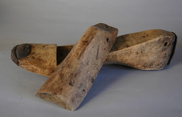 Ett par läster av trä. Varje läst består av två delar. Lagade med läder. Längd: 27 cm, tåbredd: 8 cm, hälbredd: 5,6 cm, höjd: 8,1 cm.