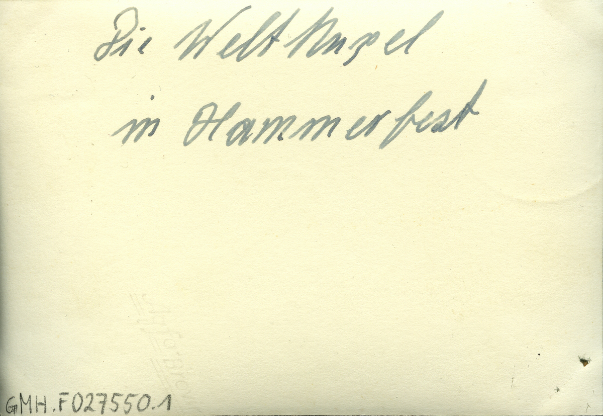 Bildet viser Meridianstøtta på Fuglenes i Hammerfest før våren 1943. På baksiden av fotografiet står det, skrevet for hånd, "Die Weltkugel in Hammerfest". Det er vinter og støtta er omgitt av et stakittgjerde. I bakgrunn ser man en stolpe med elektriske ledninger og gatelys samt et hus.