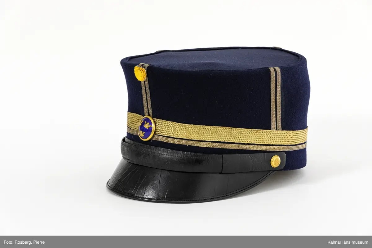 KLM 19048:4:1. Mössa. Käppi. För major. Mössa av mörkblått kläde. Rak i sidorna. Platt kulle. Svart skärm. Fyra st. dubbla stolpar av guldgalon på kullens sidor. Liten kokard av gult siden mitt fram med två plisserade ringar. Blå emaljerad mössknapp med tre kronor, under kokarden. Mössrem av svart skinn med spänne av gulmetall ovanför skärmen, fästs i mössan med liten kulknapp av gulmetall. Två rader guldgalon nära mössans nederkant, en smal och en bred. Svettrem av brunt skinn. Kullen fodrad med blankt satinvävt svart tyg. Tryckt text i guld i kullen: MILITÄR EKIPERINGS A.B. STOCKHOLM M.E.A. samt ägarinitialer  PH. V. K.
Mössan förvarades på kullen i hattask KLM 19048:4:2.