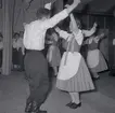 Bild tagen i samband med att flyktingar ifrån Ungern kom 1956.  Män och kvinnor som dansar. Kvinnorna dansar i traditionella romska folkträkter i Godtemplargården hösten 56 - våren 57.