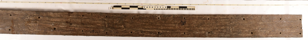 Däcksplanka i ek
Totalt 41genomgående spikhål, 20 längs plankans ena sida och 20 längs den andra. Ytterligare ett i mitten av ena änden där det också är en spricka.
Spikhålen är original från när skeppet byggdes. Originalspikarna är bortrostade. Efter bärgningen monterades däcksplankan med rostfri fransk träskruv samt bricka. Vid demonteringen 2022 lossades alla skruvar. De brickor som gick att ta bort togs bort. En del satt så djupt i träet att det inte gick att demontera dem utan att skada plankan. Dessa brickor fick därför sitta kvar.
Inristad stjärna i ena änden av plankans undersida.
Undersidan är täckt av små sprickor samt har tydliga avtryck från ribbor och däcksbalkar.