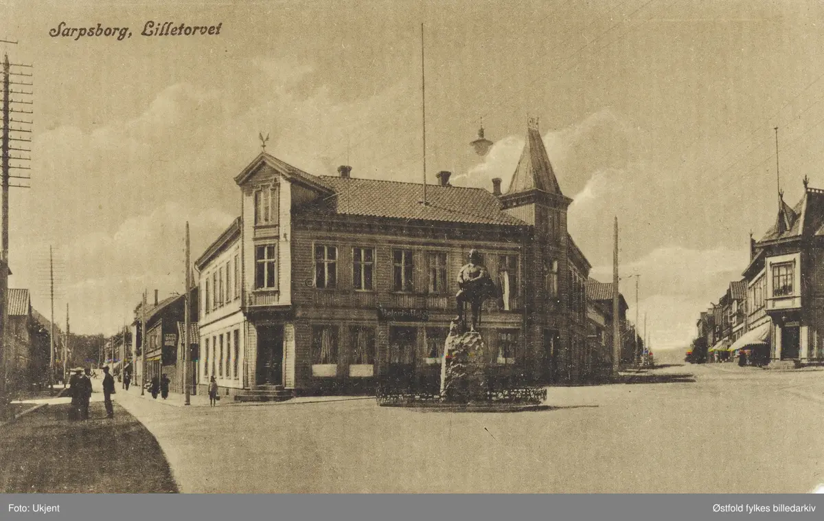 Gateparti fra Lilletorget i Sarpsborg med Glengsgata til venstre og Torggata til høyre. Statue av Olav den hellige (St. Olav), kunstner Gustav Lærum, opppført i 1916. Hotell bak statue.