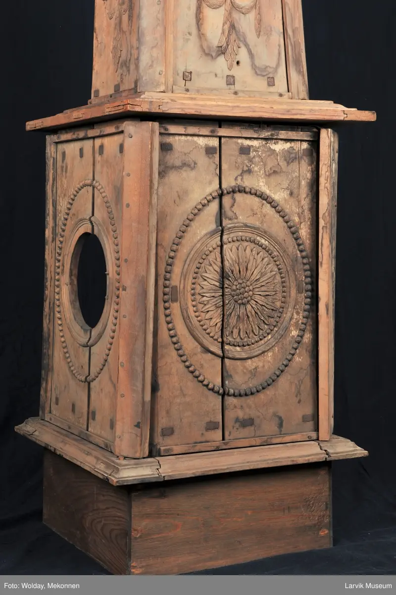 Pyramideovn. Modellplater av ovn kalt "Nr. 14". Delvis satt sammen. Underdelen firkantet med en stor rosett i oval perleramme. Høy, avsmalnende overdel med Louis XVI-ornamenter