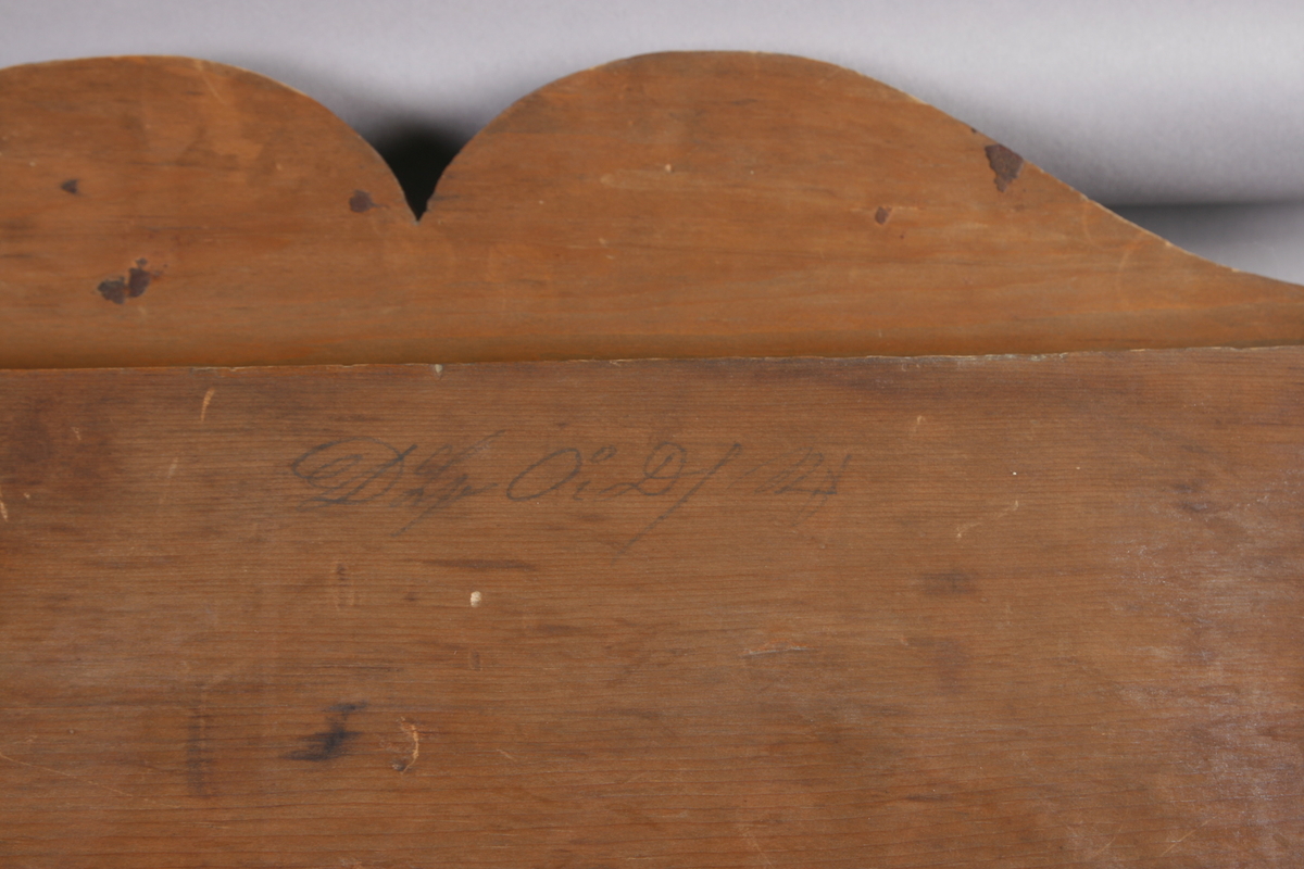 Biedermeier speil i treramme. Innfelt oval dekor på feltet på toppen. Øverst skåret dekor med sirkler. Søyler på hver side av speilet. Mahogny? Polert.