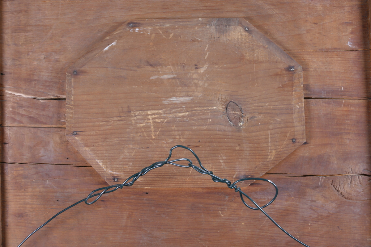 Biedermeier speil i treramme. Innfelt oval dekor på feltet på toppen. Øverst skåret dekor med sirkler. Søyler på hver side av speilet. Mahogny? Polert.