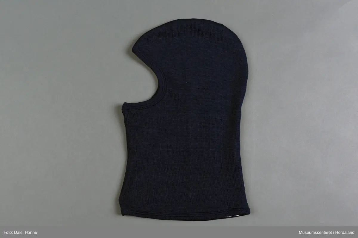Marineblå finlandshette/balaklava i eit strikka stoff i ull og syntetiske fiber. Med plastemballasje.