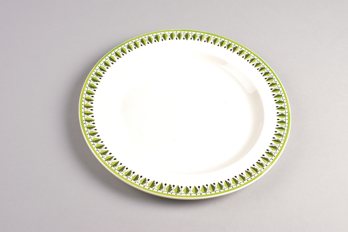 Stilisert borddekor i to grønnfarger langs kanten.