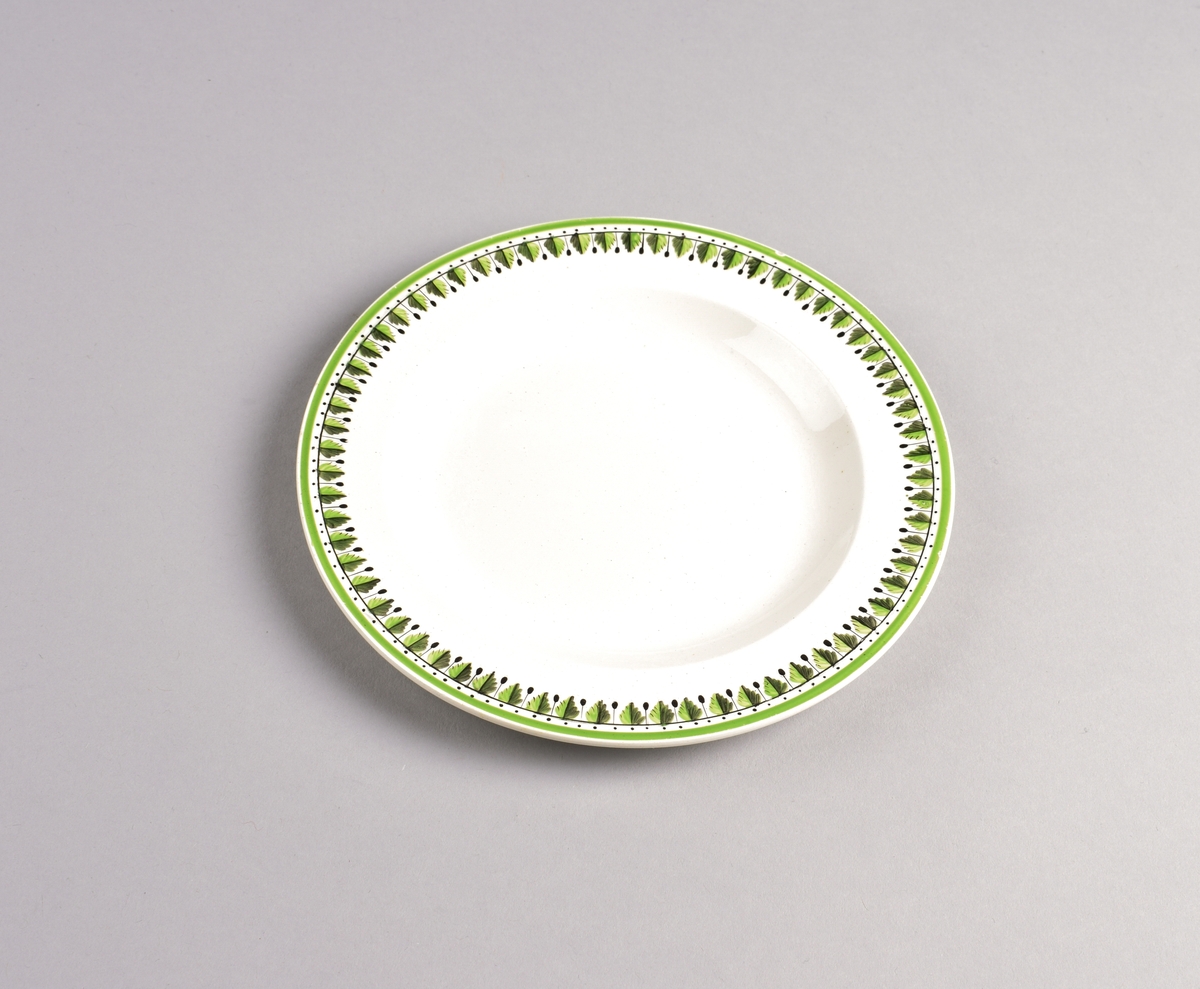 Stilisert borddekor i to grønnfarger langs kanten.