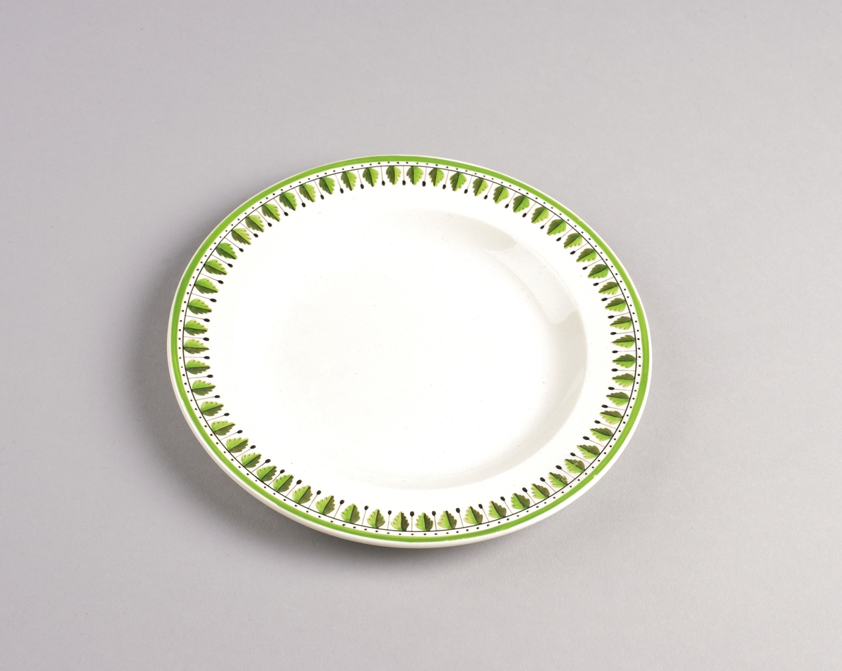 Stilisert borddekor i to grønnfarger langs kanten.