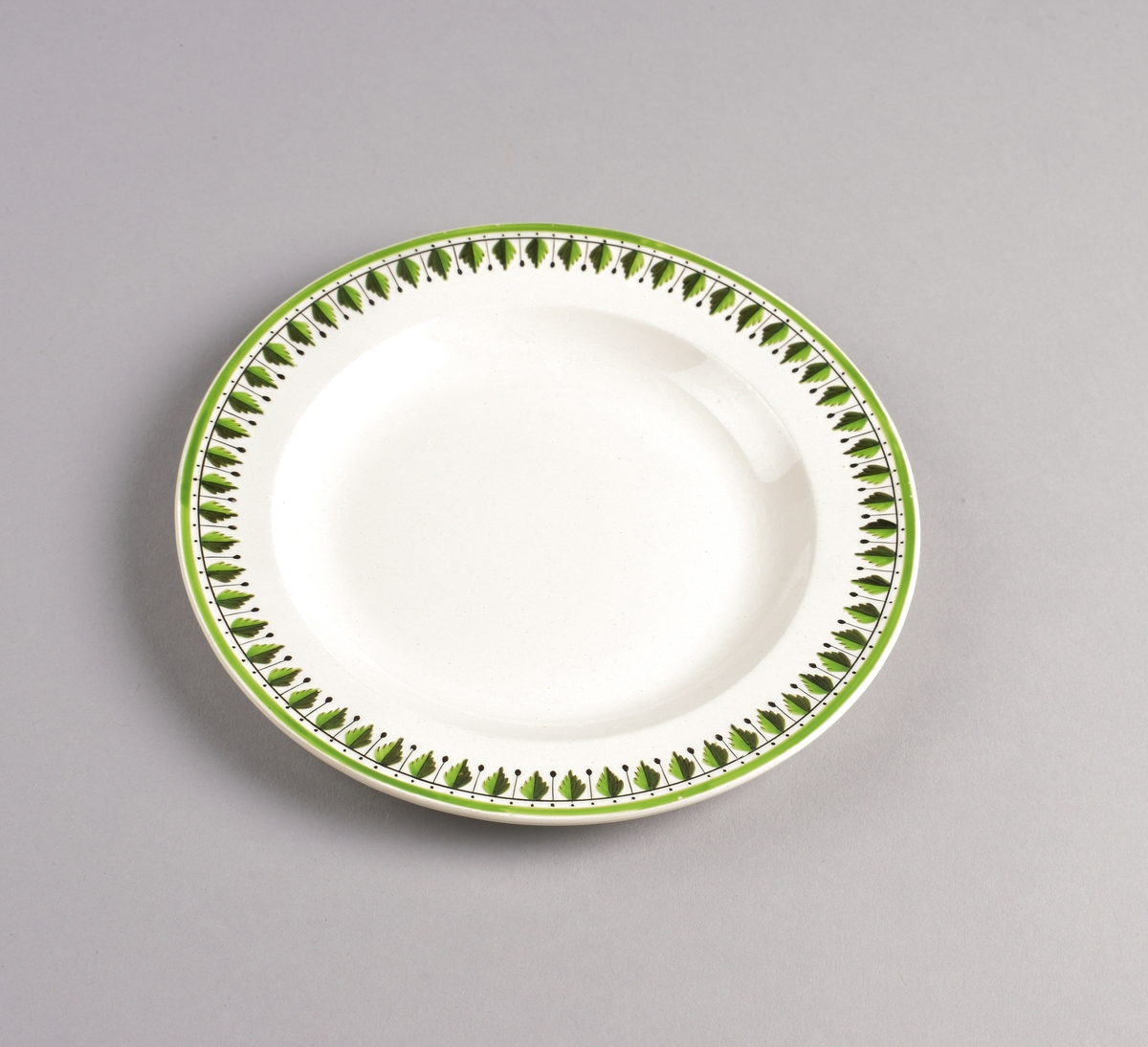 Stilisert borddekor i to grønnfarger langs kanten.