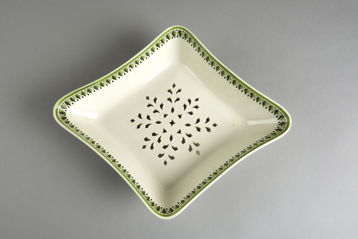 Stilisert borddekor i to grønnfarger langs kanten.