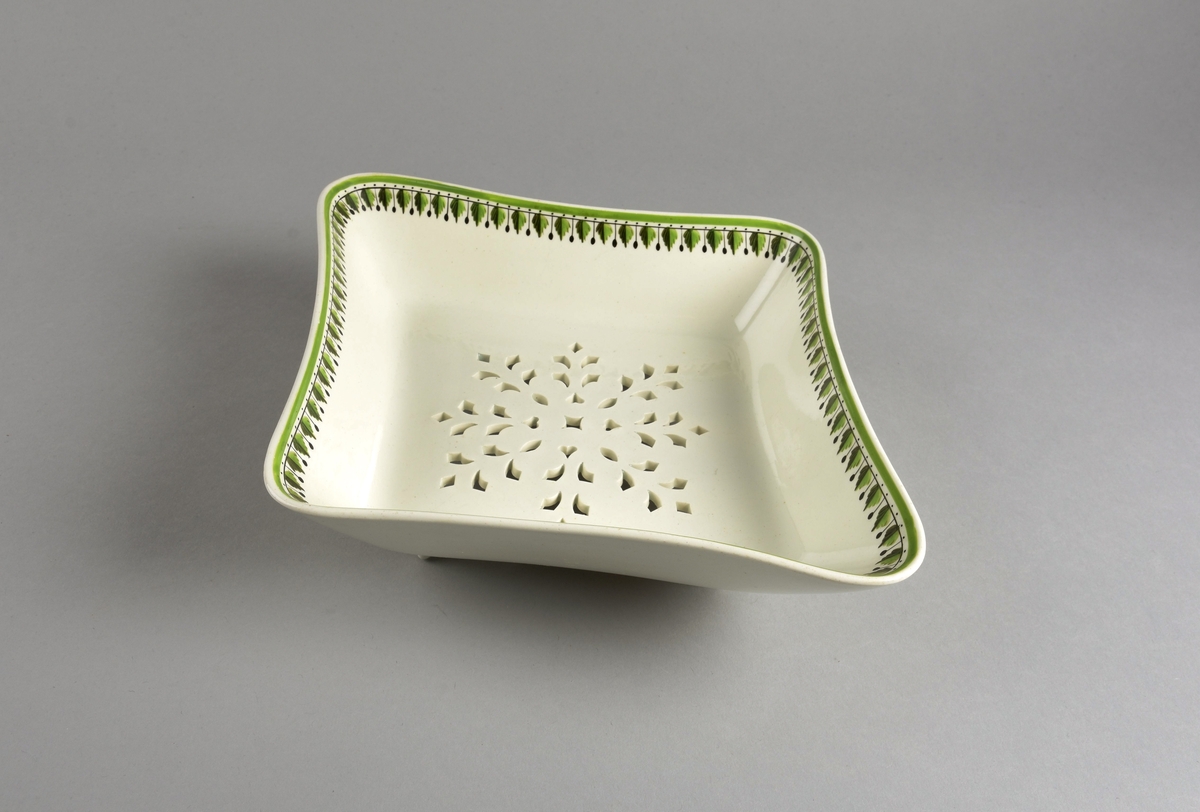 Stilisert borddekor i to grønnfarger langs kanten.