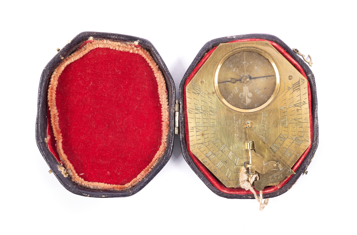 Solur och kompass av mässing. Oval åttkantigt solur med kompass under glas och en solvinkel. Graverad urtavla. Den utfällbara gnomonen (pekaren) är dekorerad med en sittande fågel justerbar för breddgraderna 40-50-60 graderInskription på baksidan: "Toulouse, Tours, Rouen, Turin, Peking, Paris, Amiens, Brest, Caen, Calais, Genes, Lyon, Madrid och Rom." Signerad "Butterfields, A Paris". Läderfodral fodrat med röd sammet.
Från omkring 1700.