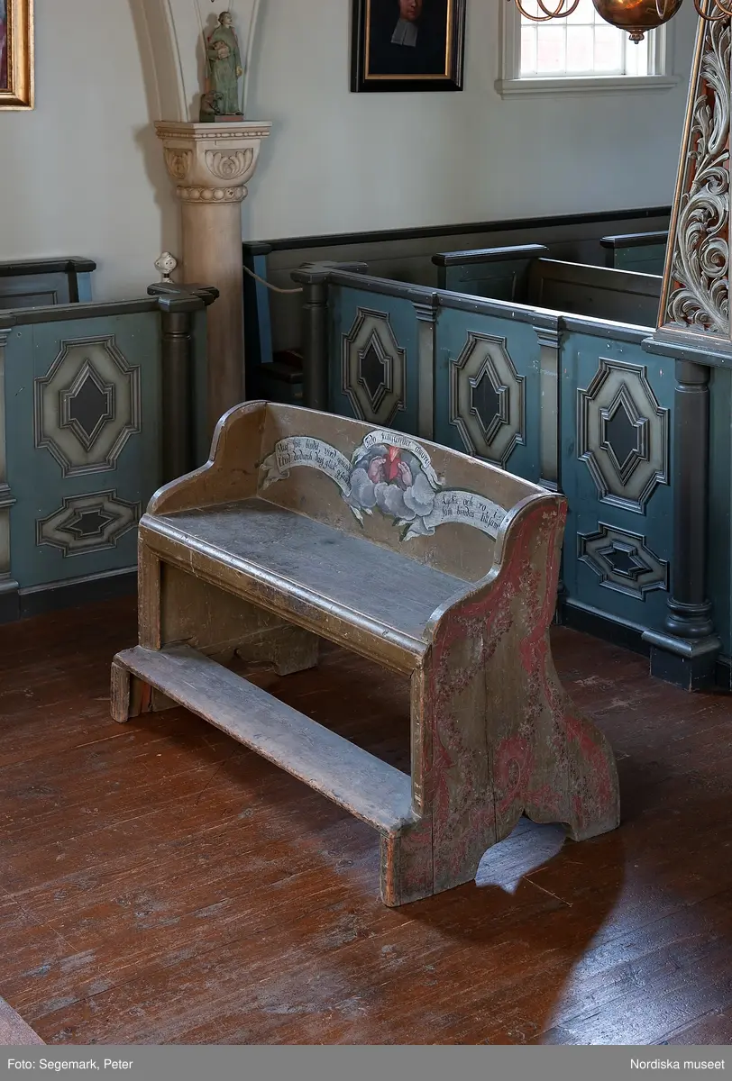 Brudstol (vigselstol) med plats för två i Julita kyrka, Södermanland. På ryggens framsida det brinnande hjärtat, en kärlekssymbol och text på tyska, latin och svenska.. Brudstolen har troligen ursprungligen stått i Arbrå kyrka, Hälsingland. Datering 1770-1780-tal.
