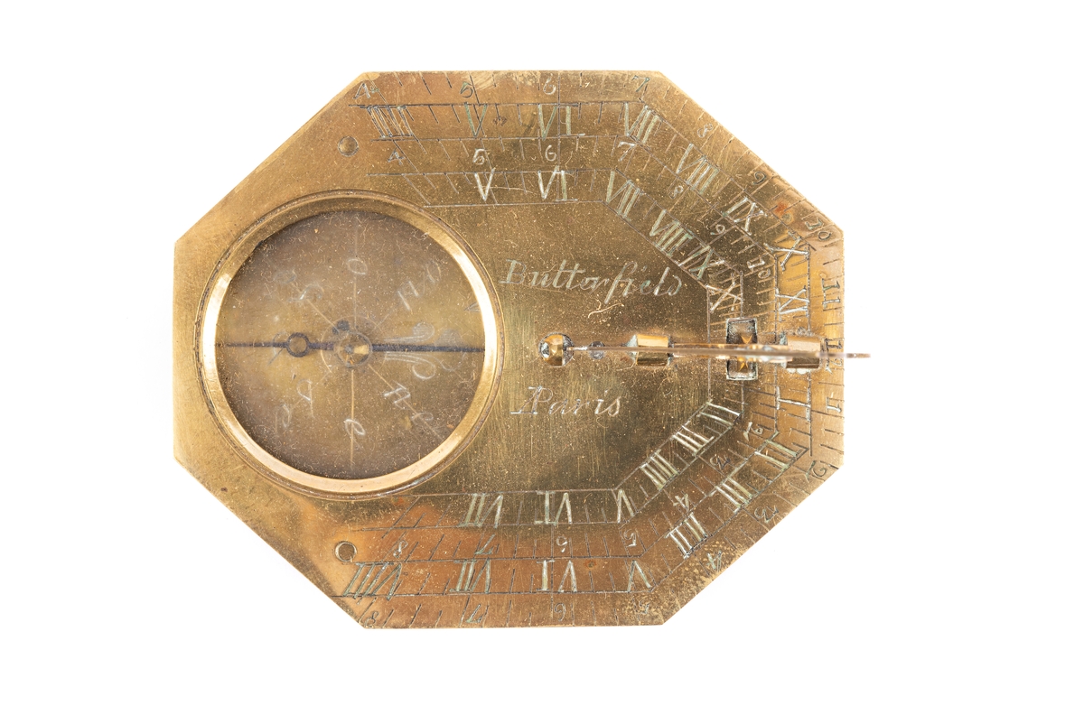 Solur och kompass av mässing. Oval åttkantigt solur med kompass under glas och en solvinkel. Graverad urtavla. Den utfällbara gnomonen (pekaren) är dekorerad med en sittande fågel justerbar för breddgraderna 40-50-60 graderInskription på baksidan: "Toulouse, Tours, Rouen, Turin, Peking, Paris, Amiens, Brest, Caen, Calais, Genes, Lyon, Madrid och Rom." Signerad "Butterfields, A Paris". Läderfodral fodrat med röd sammet.
Från omkring 1700.