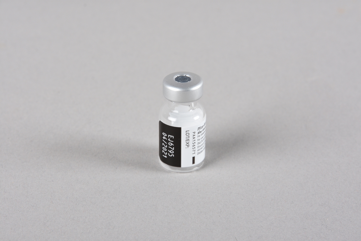 Vaksinasjonsutstyr brukt ved første vaksine mot Covid-19, satt i Bergen 05.01.2021. Utstyret består av en engangssprøyte med kanyle og beskyttelseshette og et åpnet hetteglass for Pfizer-vaksine, med tilhørende kork.