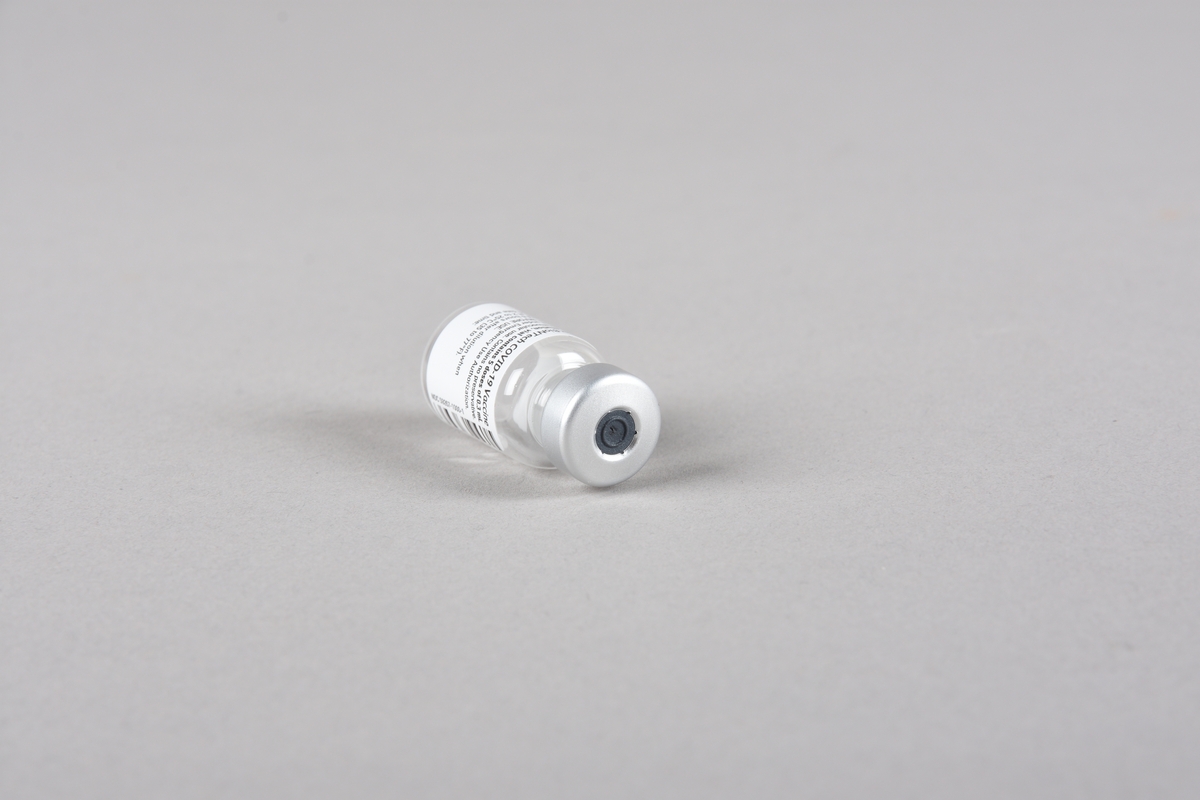 Vaksinasjonsutstyr brukt ved første vaksine mot Covid-19, satt i Bergen 05.01.2021. Utstyret består av en engangssprøyte med kanyle og beskyttelseshette og et åpnet hetteglass for Pfizer-vaksine, med tilhørende kork.