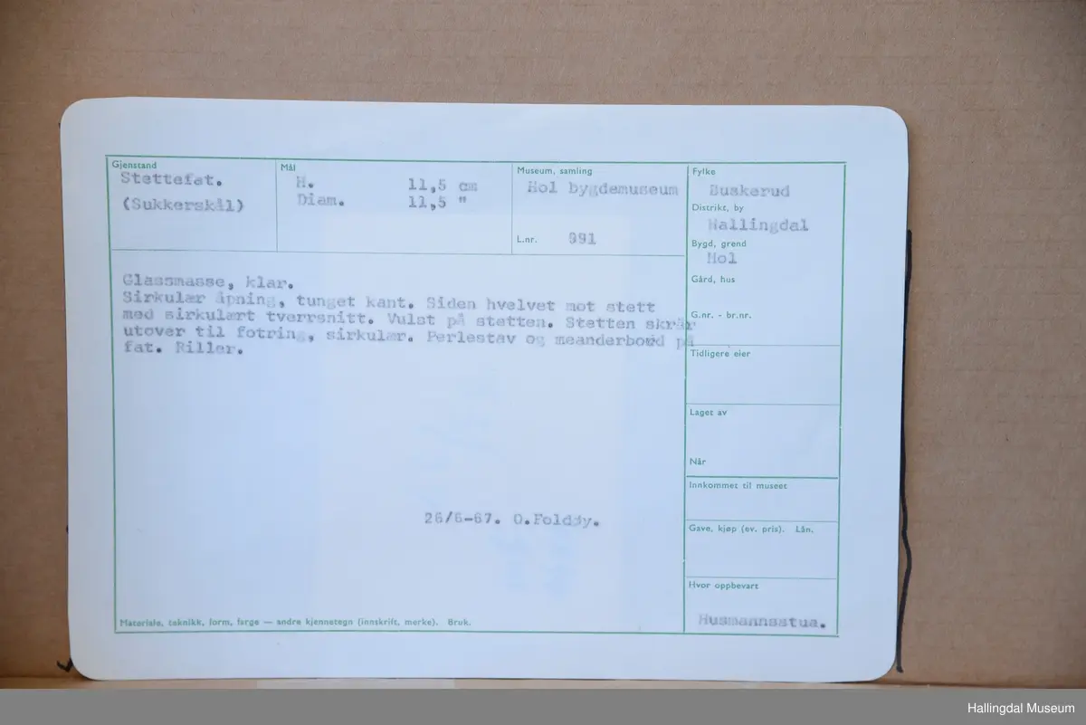 Stettefat, sukkerskål. Sirkulær åpning, tunget kant. Siden hvelvet mot stett med sirkulært tverrsnitt. Vulst på stetten. Stetten skrår utover til fotring, sirkulær. Perlestav og meanderbord på fat. Riller.
26/6-67. O. Foldøy.