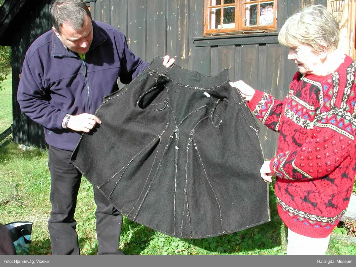 Mørk sidtrøye, fiskekjølkje i mørk brun vadmål med ståpende krage og stolper uten knapper. I ryggen er det 3 høye kiler som gjør at trøya blir videre nederst. Trøya er kantet med fløyel på ermene, bryningene og rundt hele trøya unntatt nederst der den kun er lagt opp. Hele trøya er håndsydd. Liten størrelse. Norsk institutt for bunad og folkedrakt har tegnet av mønster fra denne trøya.
Vest DAG 43 har også tilhørt Aslak Guttormsgård.