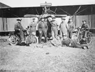 Gruppfoto av manskap vid Flygkompaniet på Malmen omkring 1920. 9 män framför flygplan Albatros, varav två sittandes på motorcykel.