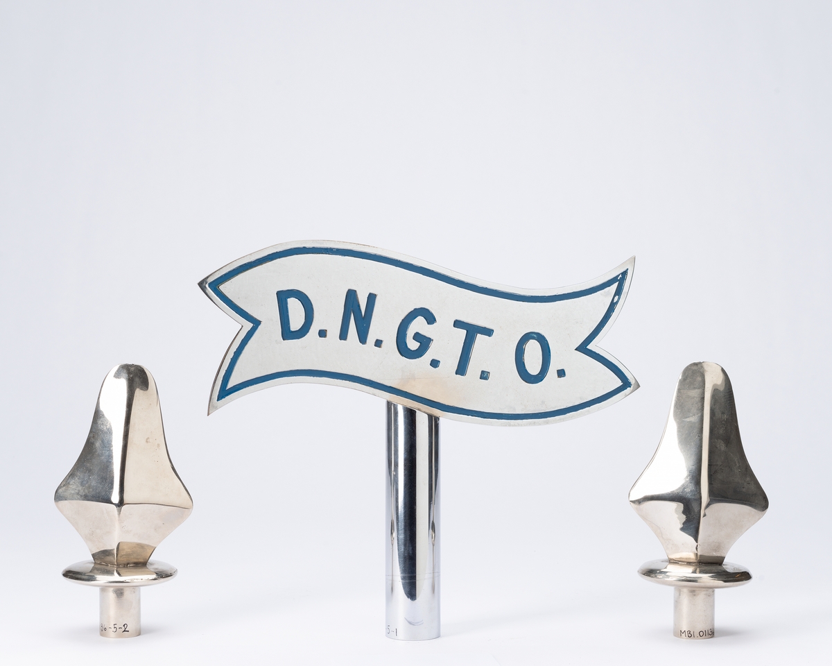 Forside: Kvinne og mann sitter i landskap med bautastein mellom seg. Han er omgitt med verktøy til å hogge i stein. På steinen er følgende innskripsjon: , "DNGTO Et kykkeligt Norge ort maal"., , Bakside: Krans av eikeblader og laubærblader.