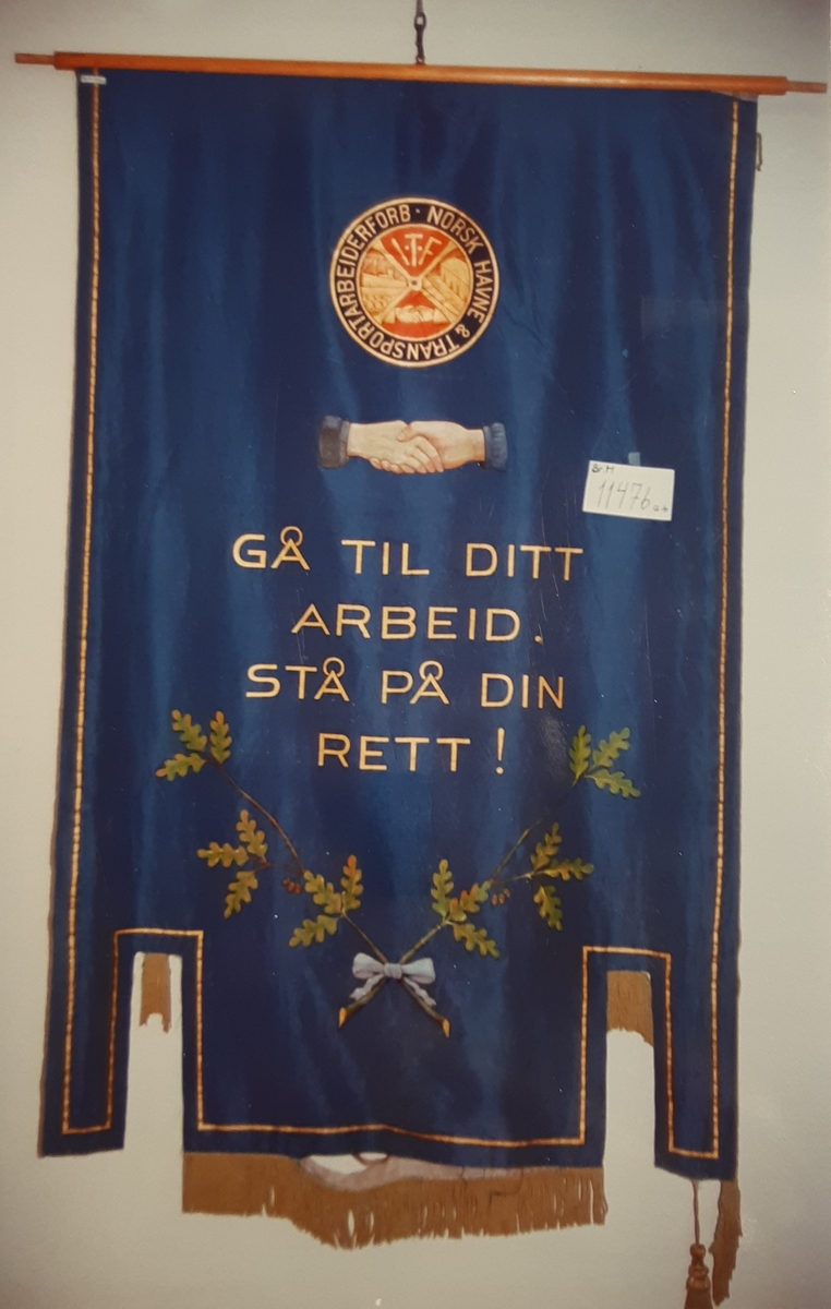 Forside: 2 skip ved kai, stuere i arbeid, vann, hus og eikeløvskrans. Det ene skipet heter "BESSA". 
Bakside: Rundt emblem, håndtrykk, eikeløv m/blå sløyfe