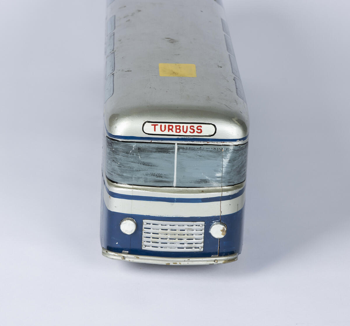Modell i en blått og sølv av tre. Modellen er en buss fra Oslo Sporveier merket som "turbuss".