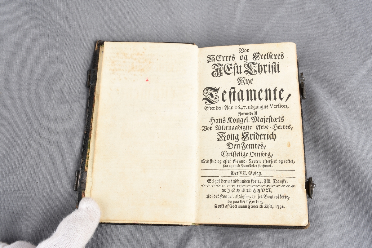 Skinninnundet bok, rektangulær form. Gulldekor preget inn i skinnet på bokens omslag. Papiret i boken har gullfarget dekor ytterst på alle sidene slik at når boken er lukket kommer gulldekoren til sin rett. Preget dekor på kortsidene av papiret. Boken lukkes med to beslag.