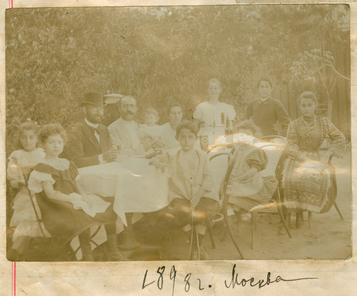 Gruppebilde av familien Rostin sittende utendørs rundt et bord. Moskva 1898, fra venstre: Elisabeth, Julia, ukjent, Michail Rostin med Serafima, Sophia Rostin, Ignazy, Valentine, Victoria, Theodor, Florentine.