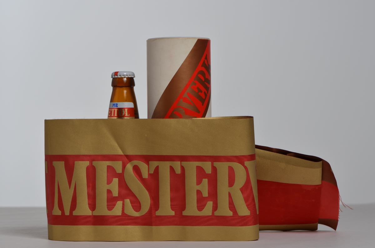 Brun lettølsflaske med emballasje og et jubileumsbånd.