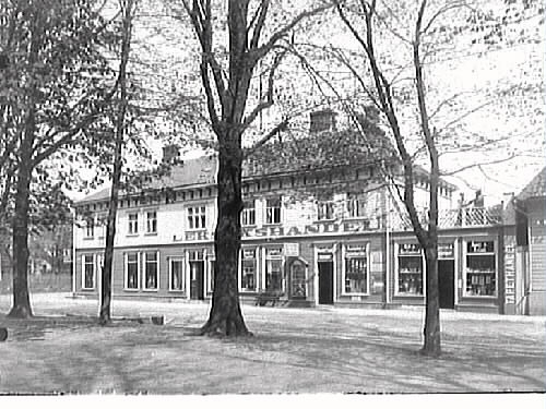 Mauritz P Lundhs färgaffär i hörnet Drottninggatan-Kyrkogatan. På fasaden över skyltfönstren står det "Leksakshandel" och till vänster "Tapethandel". Bild 2 visar fotografiet i original medan Bild 1 har gjorts till julkort genom att fälla in en tecknad tomte som bär på just leksaker i en låda på axeln.