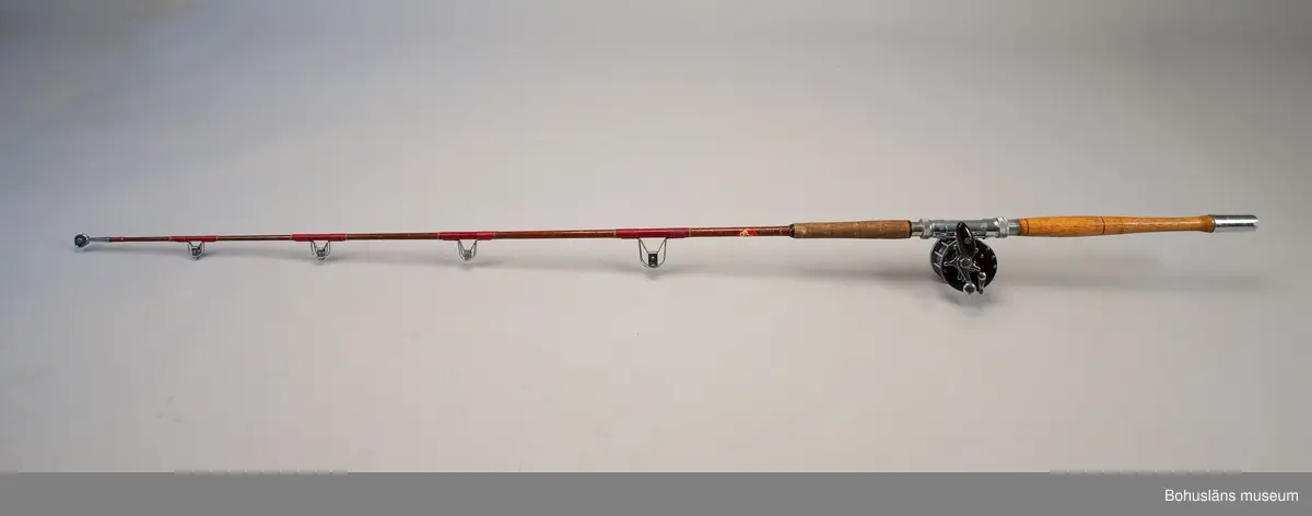 Havsfiskespö i glasfiber med havsfiskerulle för pigghaj och rocka.
Havsfiskerulle av märket True Temper.
På spöet en klisterlapp med tidningen Expressens logo, en geting.