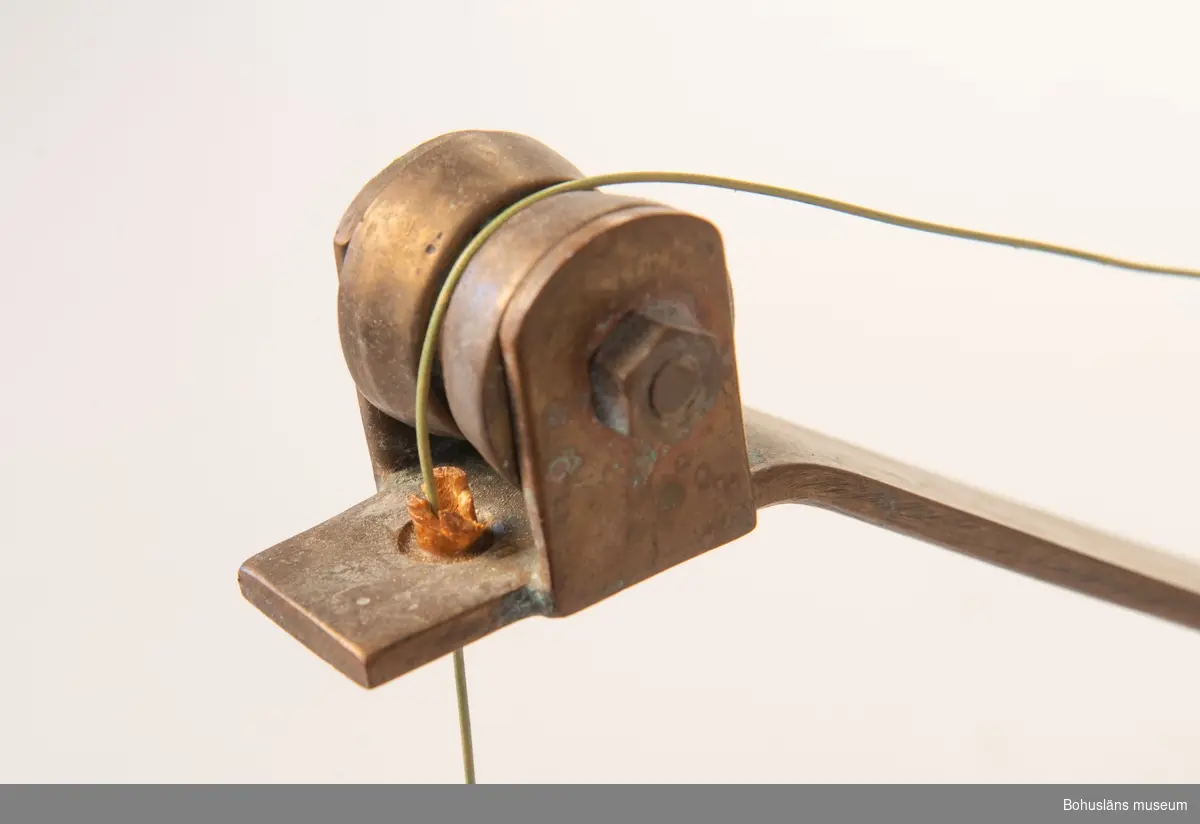 Hemmagjor manuell djuprigg. Fast bom av mässing och rulle av metall och vev med korkhandtag fästad mot en gråmålad bottenplatta. 
På rullen sitter flerfärgad nylonlina. I bottenplatta urtag för spö. Tejpad med grå tejp.
Räkneverk för  - troligen - antalet vevtag.